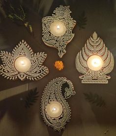 three candles are sitting on a table next to some decorative items with leaves and flowers