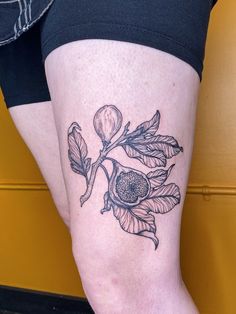 a woman's leg with a flower tattoo on her left thigh and an orange blossom on the right knee