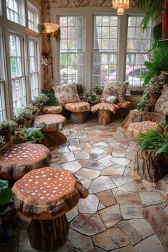 a living room filled with lots of furniture and plants on top of stone flooring