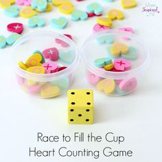 two plastic cups filled with dices next to a yellow and blue cup full of heart counting game