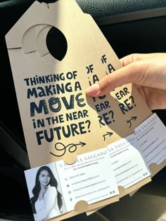 a person holding up a piece of cardboard that says thinking of making a move in the near future?