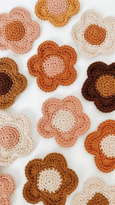 crocheted flowers arranged in rows on a white surface