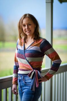 a woman standing on a porch with her hands on her hips