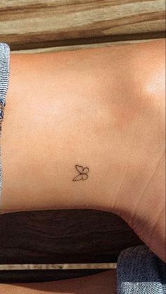 a small butterfly tattoo on the ankle