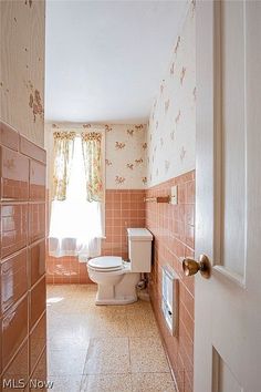 the bathroom is clean and ready for us to use it's pink tiles on the walls