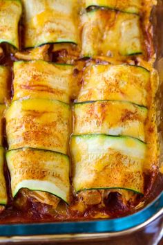 an enchilada dish with zucchini and sauce in a casserole dish