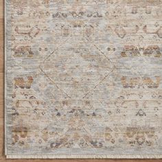 a beige and blue rug on top of a wooden floor