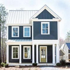 a black and white two story house with lots of windows