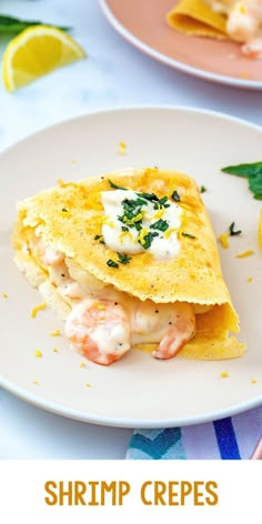 shrimp crepes on a plate with lemon wedges