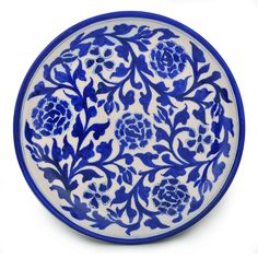 a blue and white plate with floral designs on it's rim, against a white background