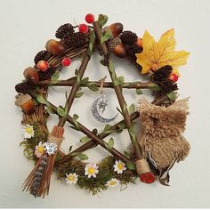 a star made out of branches, leaves and other items on a white surface with autumn colors