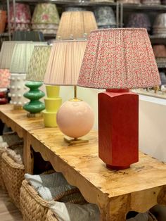 a wooden table topped with lamps and baskets