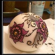 an egg decorated with flowers is sitting on a table