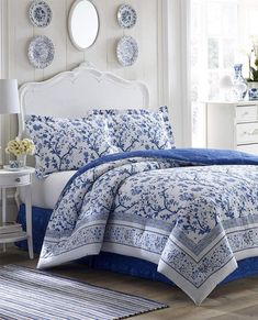 a bed with blue and white comforters in a bedroom