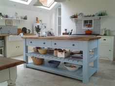 a kitchen with an island in the middle of it and skylights overhead above them