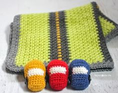 three crocheted toys are sitting on a blanket