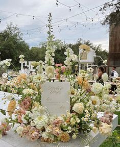 an arrangement of flowers and greenery on display at a wedding reception in the garden