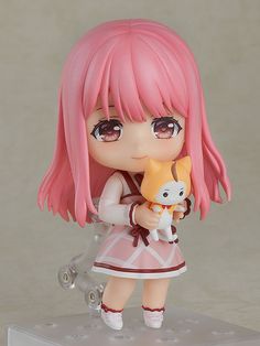 a doll with pink hair holding a cat on top of a white shelf next to a gray wall