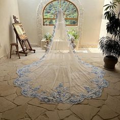 a wedding veil is shown in front of an arched doorway with potted plants on either side