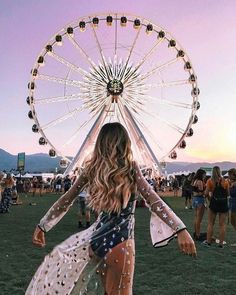 a woman standing in front of a ferris wheel