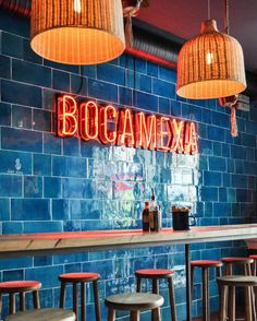 the interior of a mexican restaurant with blue tiles and red lights hanging from the ceiling