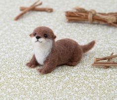 a small stuffed animal sitting on top of a floor next to sticks and twigs in front of it