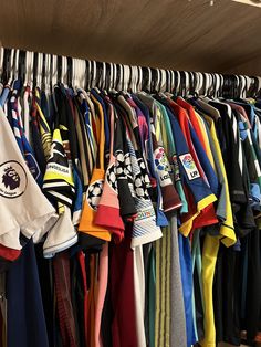 a bunch of shirts are hanging on a rack