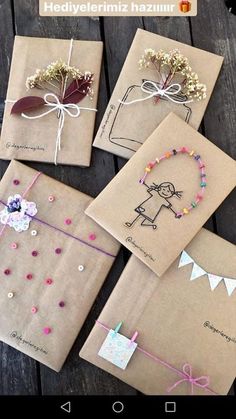 four brown paper bags with different designs on them and string attached to each bag, tied together