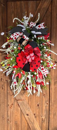 a red and black christmas wreath on a wooden door