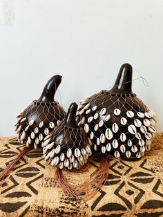 two decorative black and white pumpkins sitting on top of a brown tablecloth covered floor