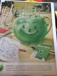 an advertisement with a green smiley face in a glass pitcher and notepad next to it