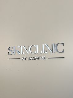 the sign for skin clinic by jasmine in silver lettering on a white wall