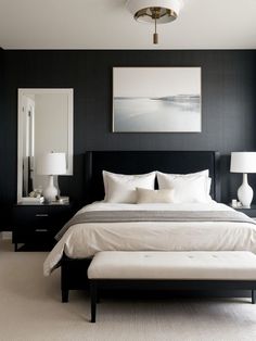 a bedroom with black walls and white bedding