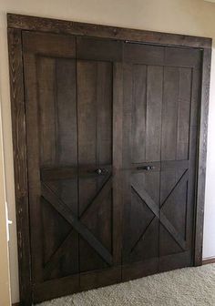 a large wooden closet with sliding doors in the corner and carpet on the floor next to it