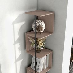 a three tiered shelf with books and flowers on it in the corner of a room