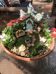 a potted planter filled with lots of flowers and small gnome figurines