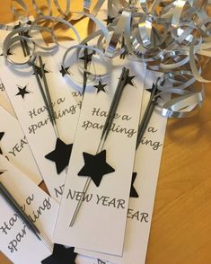 five new year's eve tags with scissors and streamers on a wooden table