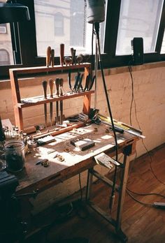 an old workbench with many tools on it in front of a large window