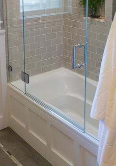 a bathtub with glass doors in a bathroom