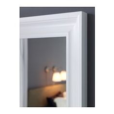 a white framed mirror hanging on the wall