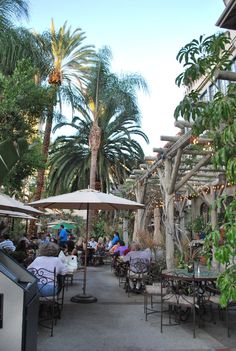 an outdoor dining area with tables and umbrellas