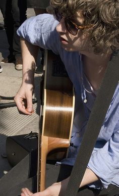 a young man is playing an acoustic guitar