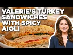 a woman standing in front of a sandwich on a plate with the words valerie's turkey sandwiches with spicy aioii