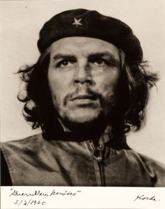 a black and white photo of a man with long hair, wearing a baseball cap