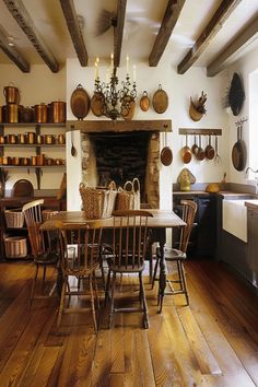 an old fashioned kitchen with wood flooring and exposed beams in the ceiling, along with wooden dining table surrounded by wicker chairs