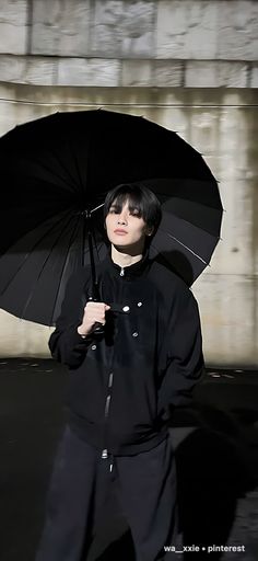 a person holding an umbrella in front of a building