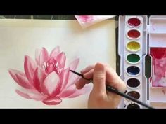 someone is painting a pink flower with watercolors