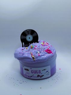 a purple cake with sprinkles and a record on it's top