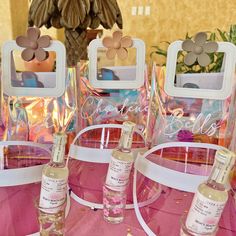 three bottles of perfume sitting on top of a table next to mirrors and vases