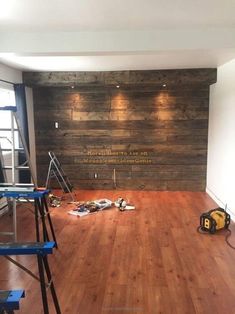 an empty room with hard wood flooring and construction tools on the ground in front of it